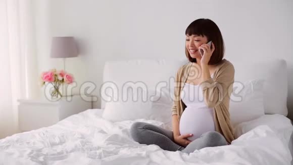 快乐的孕妇在家打电话给智能手机视频的预览图