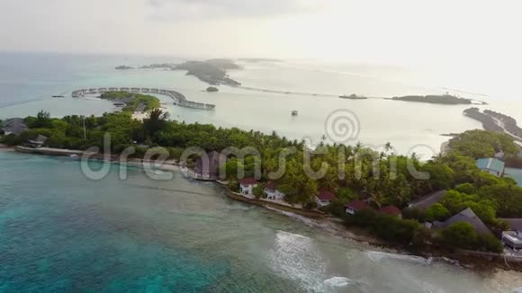 在马尔代夫有白沙棕榈树和绿松石印度洋的热带岛屿度假酒店的无人机视频的预览图