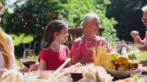 晚餐或夏日花园派对的快乐家庭视频的预览图