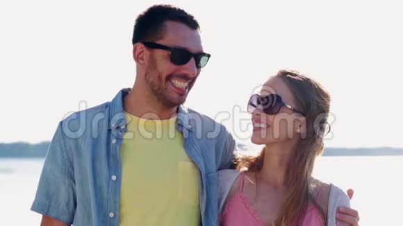 快乐的一对夫妇戴着太阳镜拥抱大海视频的预览图