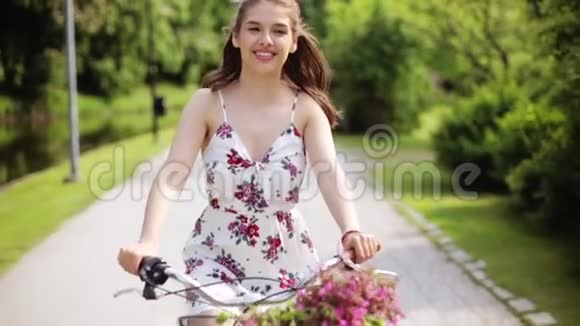 夏日公园骑自行车的快乐年轻女子视频的预览图