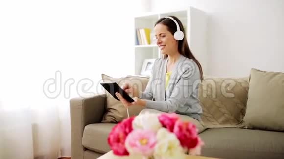 带平板电脑和耳机的幸福女人视频的预览图