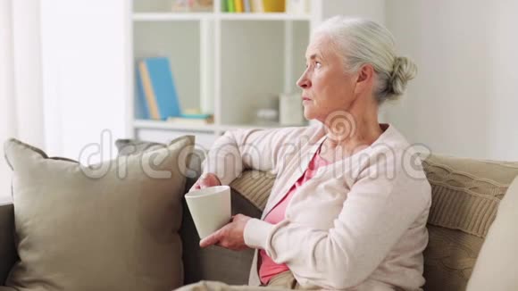 家里有一杯茶或咖啡的老妇人视频的预览图