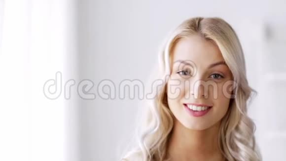 微笑的美丽年轻女人的脸视频的预览图