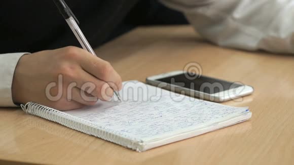 学生用钢笔在笔记本上写课文视频的预览图