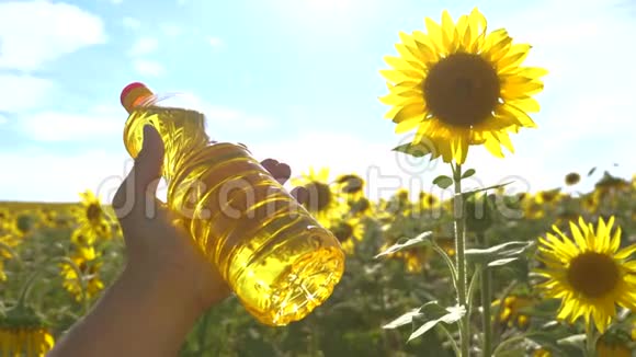 农夫手里拿着一瓶生活方式的葵花籽油手里放着阳光慢动作视频农业视频的预览图