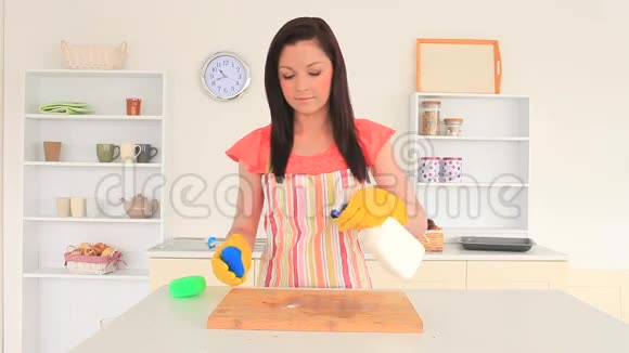 年轻的黑发女人打扫厨房视频的预览图