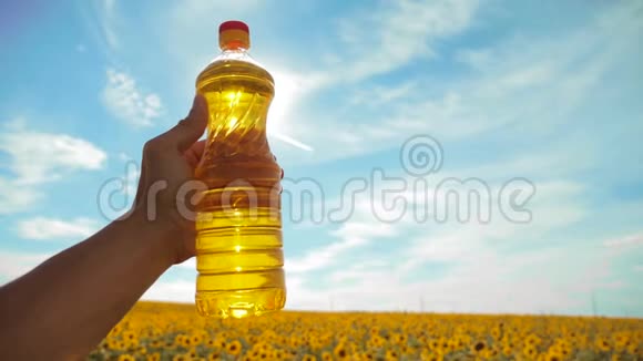 慢动作录像日落时分农夫手捧一瓶葵花籽油农民农业塑料视频的预览图