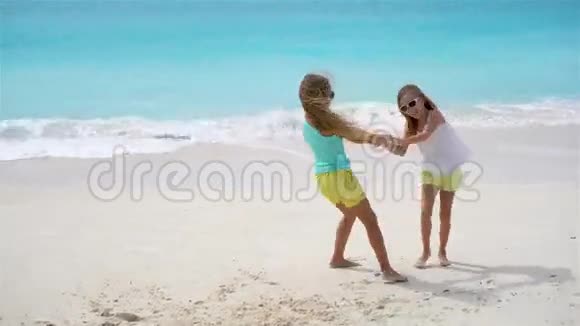 可爱的小女孩一起玩在白色的热带海滩视频的预览图