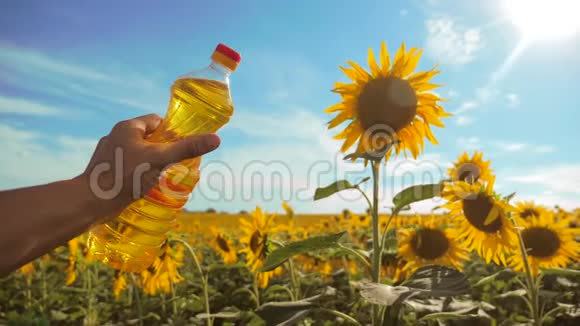 慢动作视频日落时分农夫手里拿着一瓶生活方式向日葵油人农农业视频的预览图