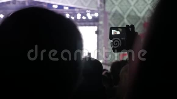 音乐音乐会上的人群在明亮多彩的舞台灯光前喧闹的人群生活方式音乐会人群的剪影视频的预览图