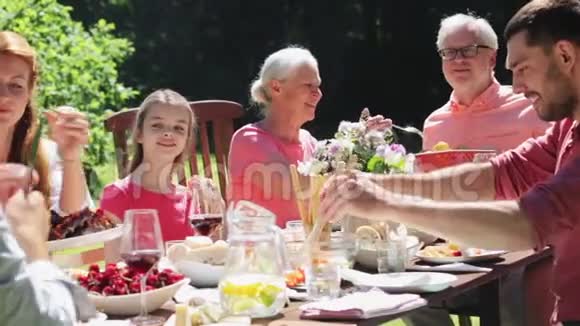 晚餐或夏日花园派对的快乐家庭视频的预览图