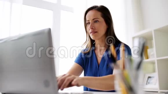 家里或办公室有笔记本电脑和笔记本的女人视频的预览图