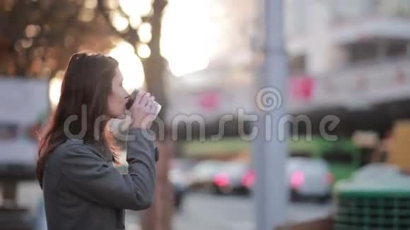 美丽的女人在街上喝咖啡视频的预览图