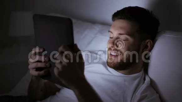带平板电脑的年轻人在家卧室的床上视频的预览图