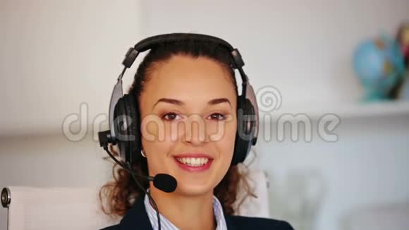 在呼叫中心工作的带耳机的年轻女性画像视频的预览图