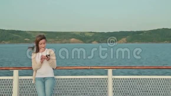 在游轮甲板上使用手机的女人视频的预览图