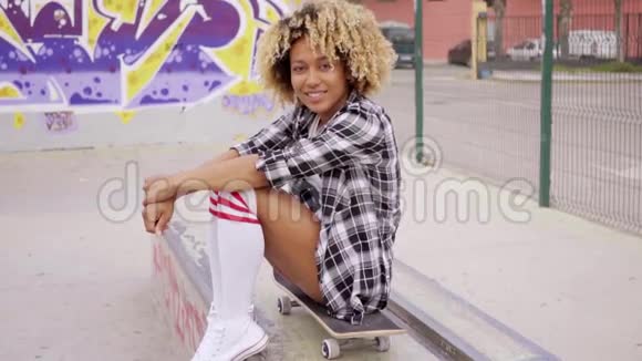 时髦的年轻女人坐在滑板上视频的预览图