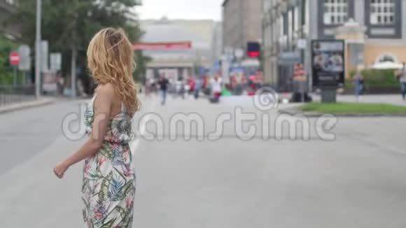 美丽的金发女郎在城市里走来走去视频的预览图