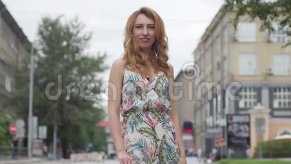 美丽的金发女郎在城市里走来走去慢动作视频的预览图