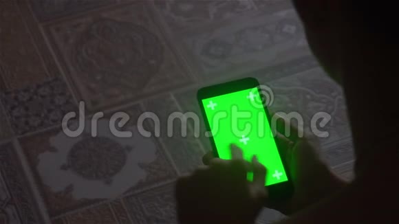 一个年轻人和绿色屏幕智能手机视频的预览图