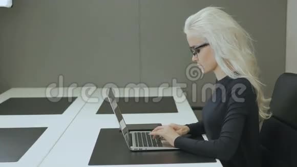 漂亮的商务女孩在办公室用笔记本电脑工作视频的预览图
