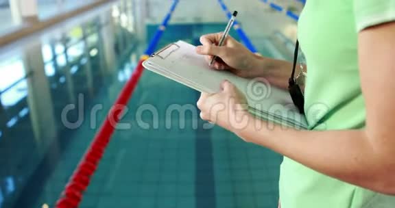 漂亮的教练站在泳池边视频的预览图