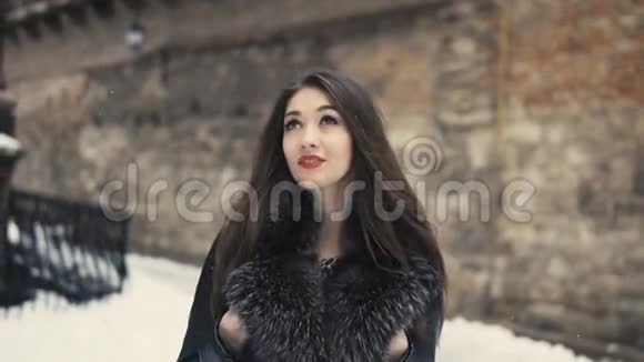 雪中漫步的美丽黑发女孩视频的预览图
