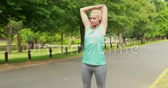 在公园里伸展身体的健康女人视频的预览图