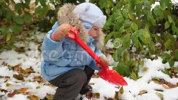 在公园里玩雪铲的孩子视频的预览图