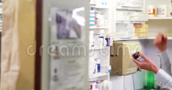 药剂师在药房检查一瓶药视频的预览图