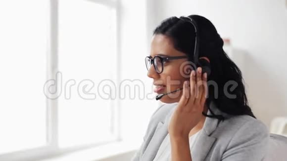 办公室里戴耳机的女商人视频的预览图