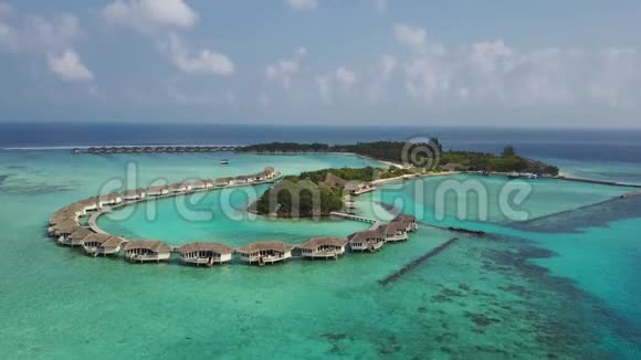 带白沙棕榈树和绿松石印度洋的热带岛屿度假酒店的空中景观视频的预览图