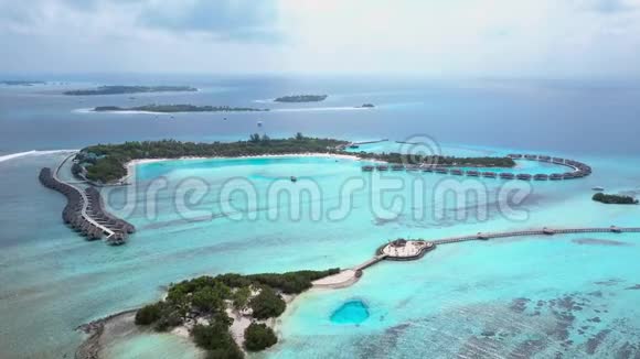 带白沙棕榈树和绿松石印度洋的热带岛屿度假酒店的空中景观视频的预览图