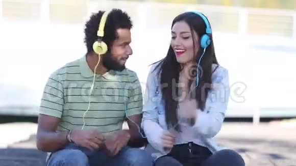 可爱的年轻夫妇带着耳机听音乐跳舞视频的预览图