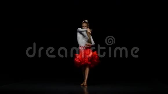 在录音室里在黑暗背景下跳拉丁舞的女孩视频的预览图