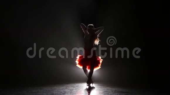 一个美丽的女孩在一个黑暗的背景烟雾剪影的工作室里跳伦巴舞视频的预览图