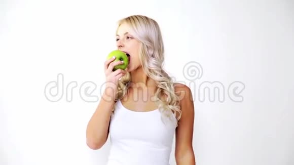 快乐美丽的姑娘吃绿苹果视频的预览图