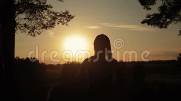 日落时森林里女人的剪影自由概念视频的预览图