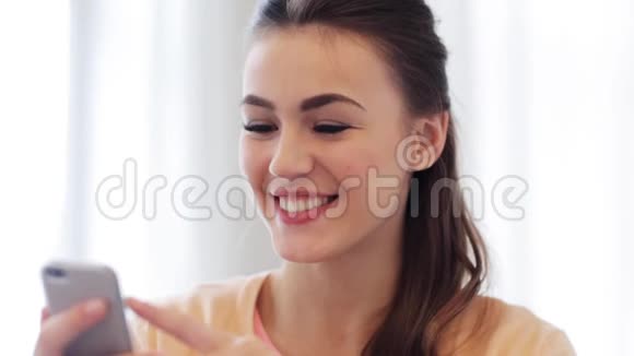 快乐微笑的年轻女人带着智能手机视频的预览图