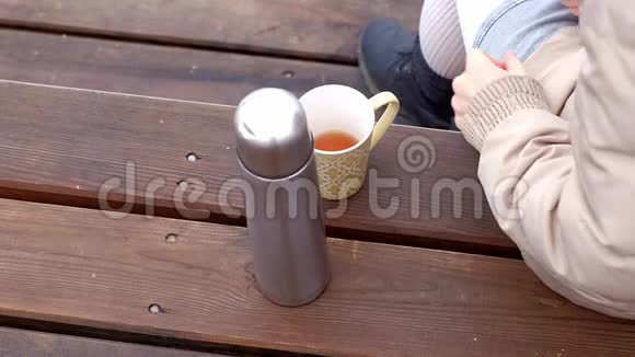 浪漫的年轻女人在海滩上放松喝热茶或热水瓶咖啡平静舒适的夜晚视频的预览图