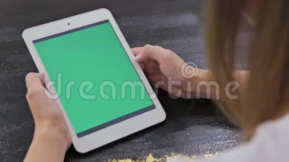 女人用的是绿色屏幕的平板电脑视频的预览图