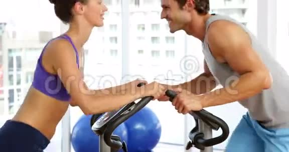 健身情侣在健身室骑自行车锻炼视频的预览图