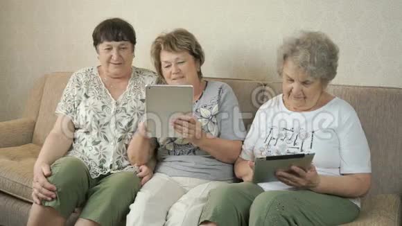 在家里拿着数码平板电脑的老年妇女视频的预览图