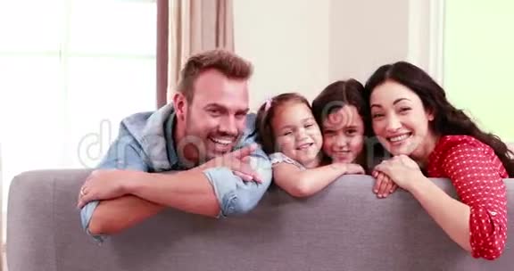 微笑的一家人在沙发上摆姿势视频的预览图