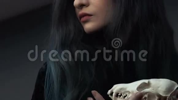 一个年轻女孩拿着一个神秘的头骨在狐狸手中的肖像染的长发视频的预览图