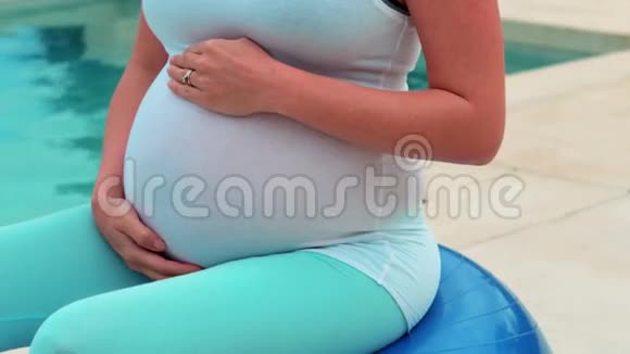 孕妇在运动球上摸肚子视频的预览图