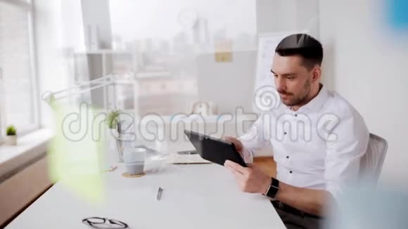 办公室里有平板电脑和咖啡的商人视频的预览图