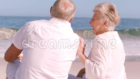 坐在沙滩上的成熟夫妇视频的预览图
