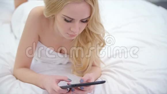 可爱的金发女孩躺在床上视频的预览图